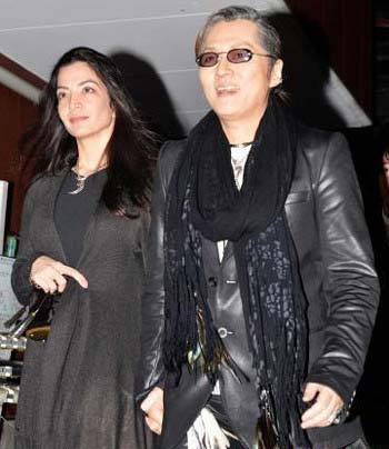 ラジオの公開収録後、マリーザ夫人(左)と手をつなぎ会場を出る石井竜也