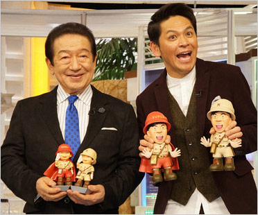 スーパーヒトシくん人形を持つ草野仁＆ますおか岡田圭右『世界ふしぎ発見！』司会